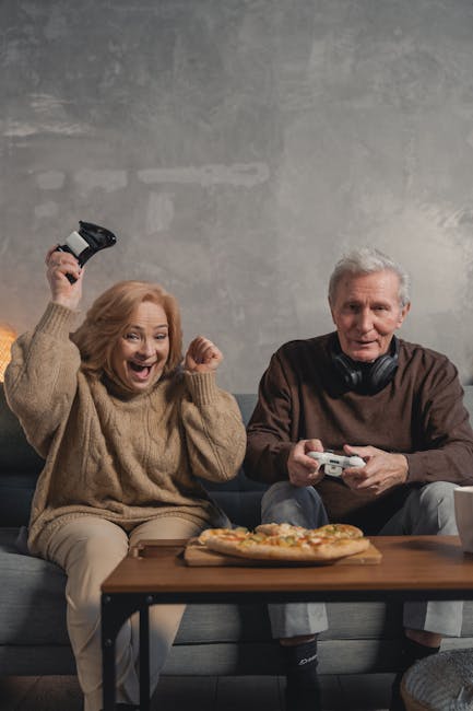 Happy senior couple playing video games together, celebrating a win.